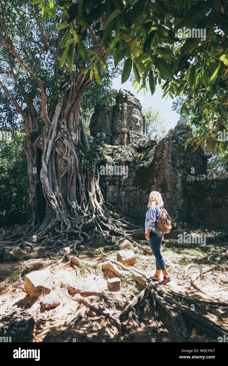 Kaukasische blonde Frau, die Entdeckung der Ruinen von Angkor Wat Tempel Komplex in Siem Reap, Kambodscha. Baum auf dem Dach des Tempels Eingangstor arc Stockfoto