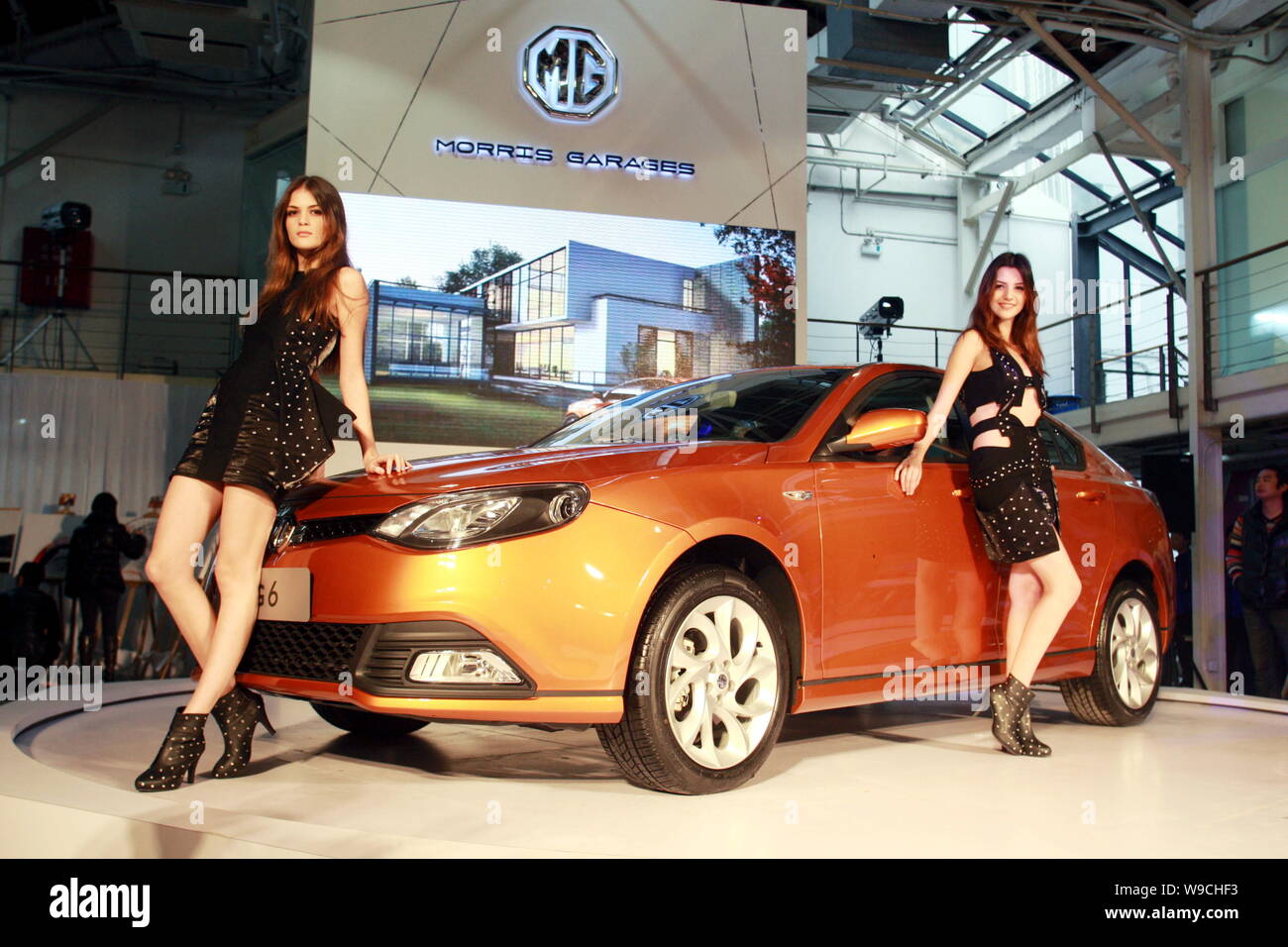 Modelle posieren mit einem MG 6, die von der SAIC Motor hergestellt, während ein in Shanghai, China, 10. Dezember 2009. Shanghai Automotive Industry Adr Stockfoto