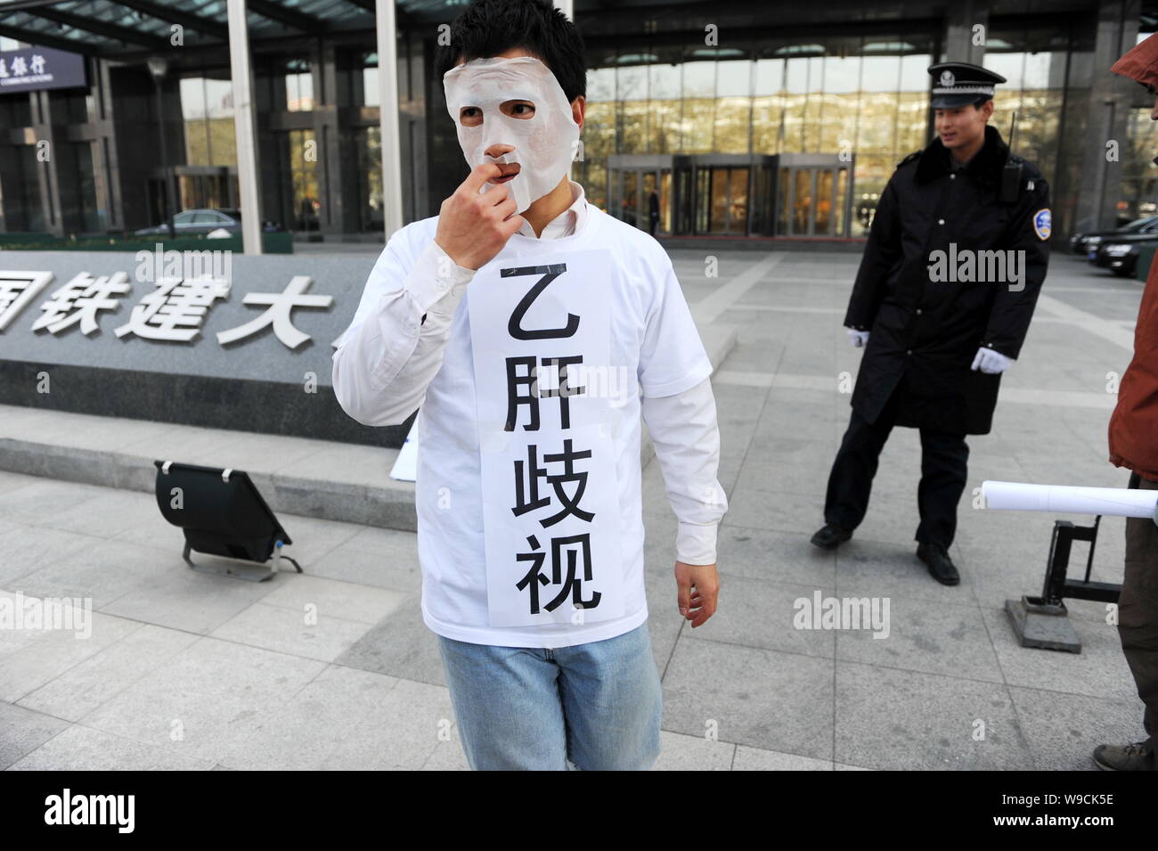 Einen chinesischen Buergerrechtler mit den Aufschriften Diskriminierung gegen Hepatitis-B-Virus-Träger Protest vor der Zentrale von China Rail Stockfoto