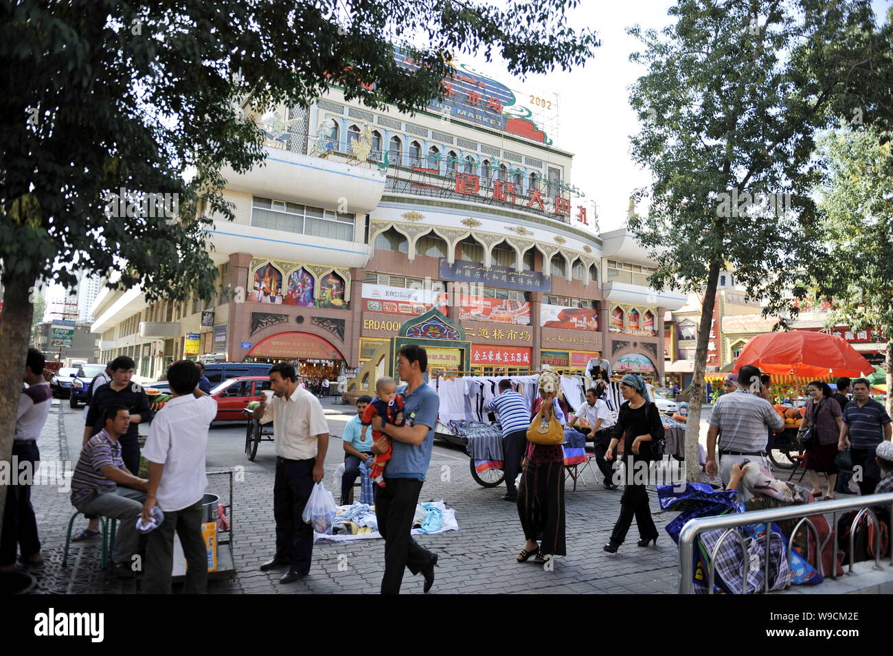 Lokalen chinesischen Uigurischen Bürger vorbei an Ständen vor dem Erdaqiao Basar in Urumqi im Nordwesten Chinas Autonome Region Xinjiang Uygur, 12. Juli 20. Stockfoto