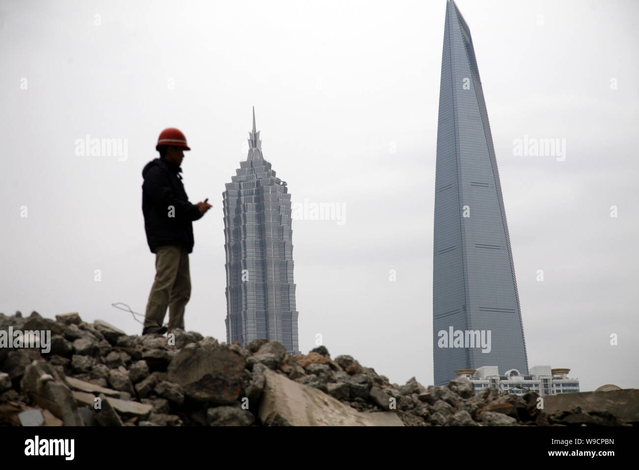 Eine chinesische Bauarbeiter steht auf den Trümmern der alten Häuser für den Bau von neuen Immobilien Projekte in der Nähe des Bund im Huangpu D zerstört Stockfoto