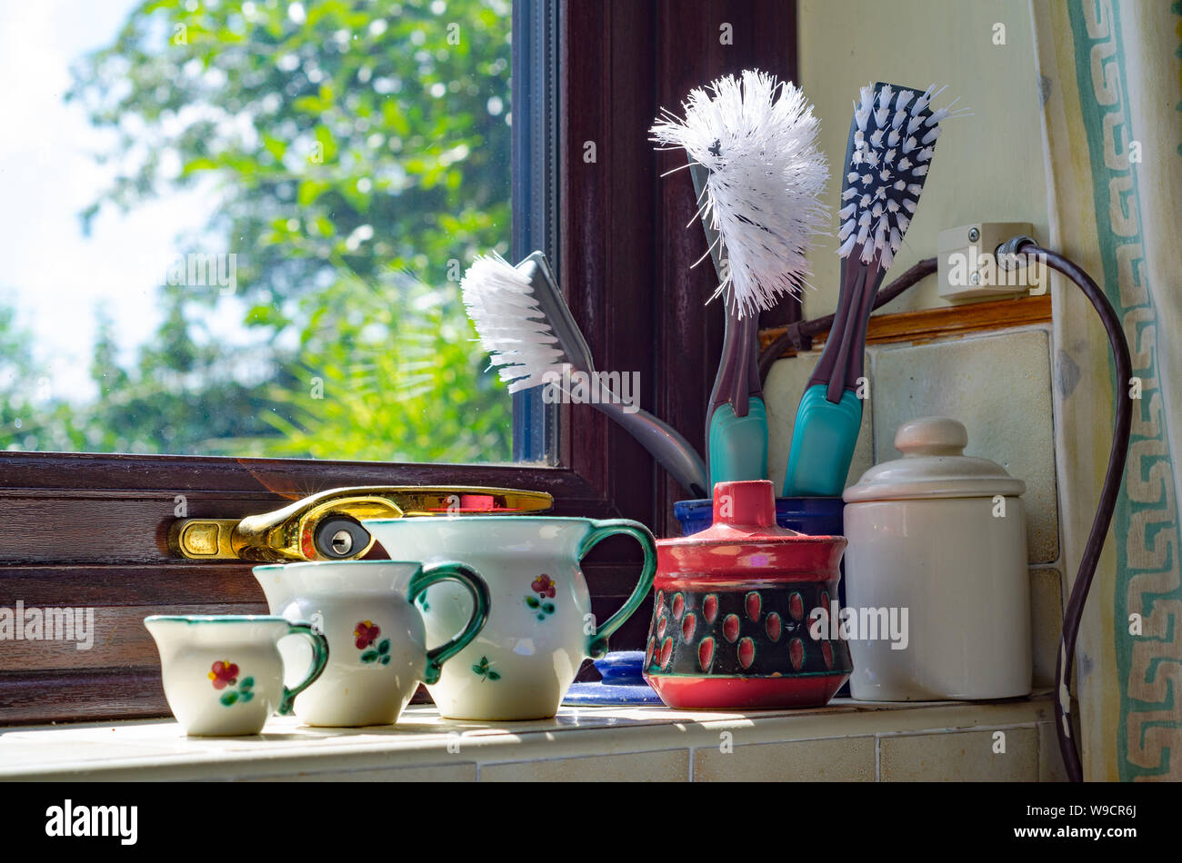Töpfe, Krüge und Waschbürsten saß am Ende einer Küche Fensterbank. Stockfoto