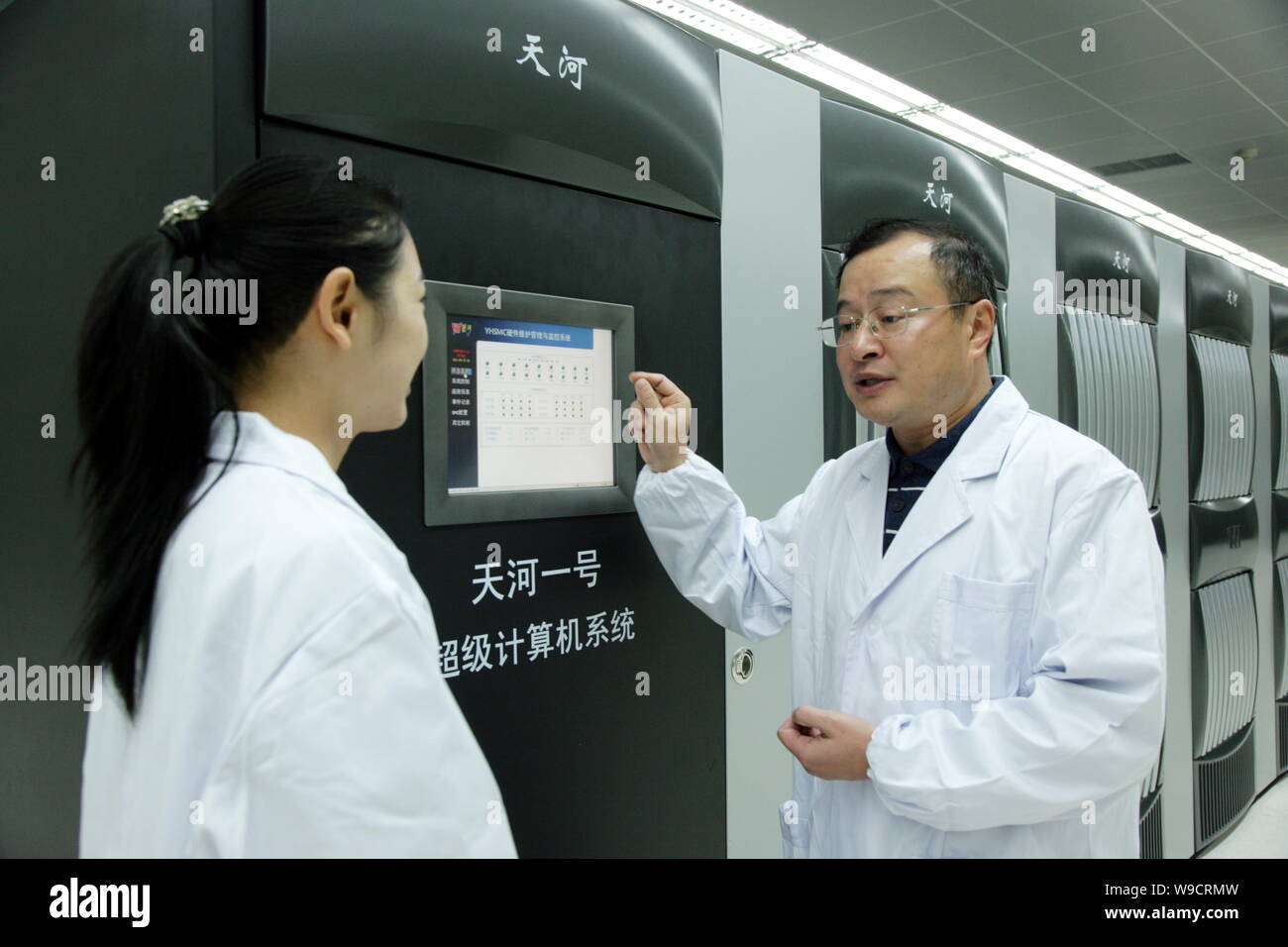 Eine chinesische Forscher, rechts, stellt der Supercomputer Tianhe Nr. 1 an der Nationalen Universität von Wehrtechnik in Changsha City, Central China Stockfoto