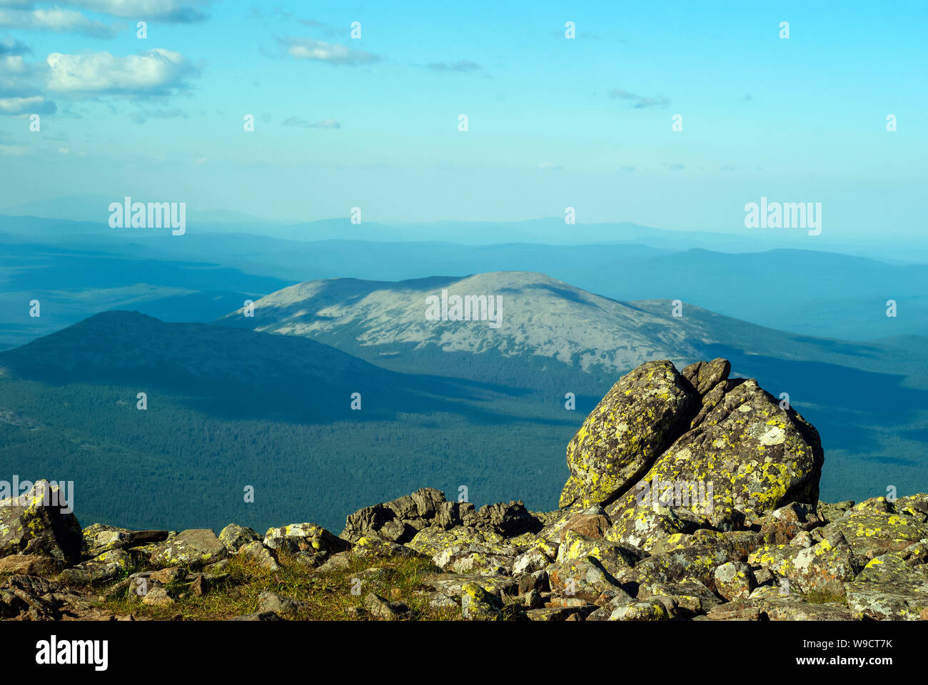 Blick vom Gipfel des Mount Konzhakovskiy Kamen-Abschnitt des Berges Tundra mit Flechten bewachsene Felsen und einen Blick auf die bewaldeten Berge der horizo Stockfoto