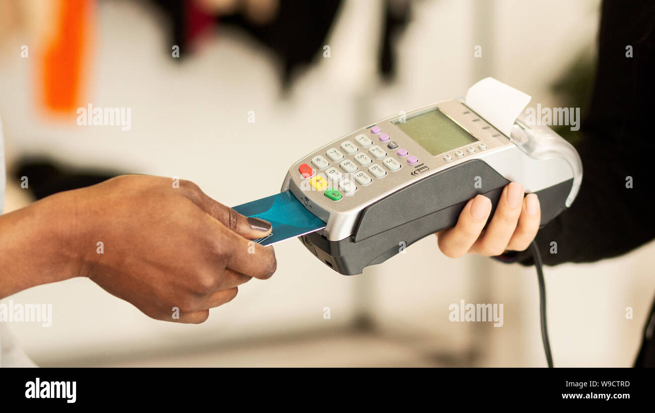 Kunden bezahlen für Kleidung per Kreditkarte in Designer Boutique Stockfoto