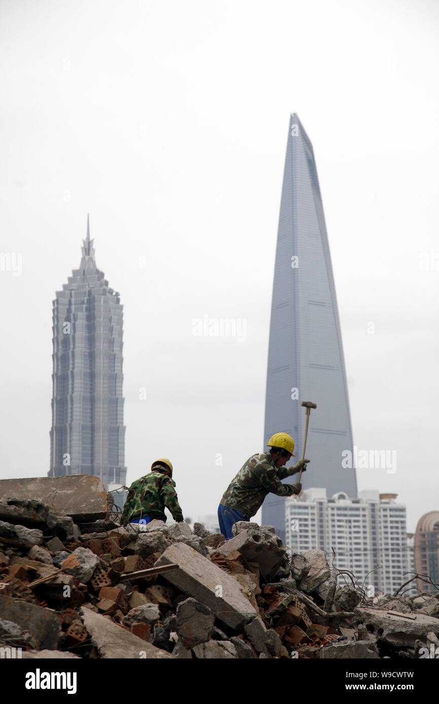 Chinesische Bauarbeiter demontieren alte Häuser für den Bau von neuen Immobilien Projekte in der Nähe des Bund im Huangpu District als Jinmao Tower, Stockfoto