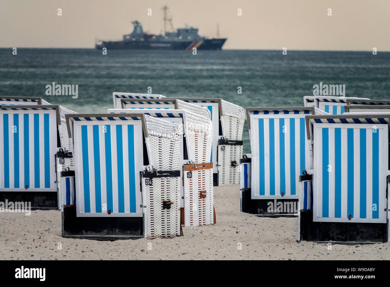 Warnemunde Strandstühle. Deutschland Küstenwache Boot Hintergrund Stockfoto