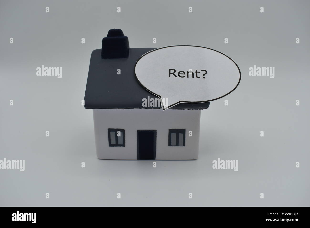 Ein Modell Haus mit dem Wort "Mieten?" in einer Sprechblase auf dem Dach. Stockfoto