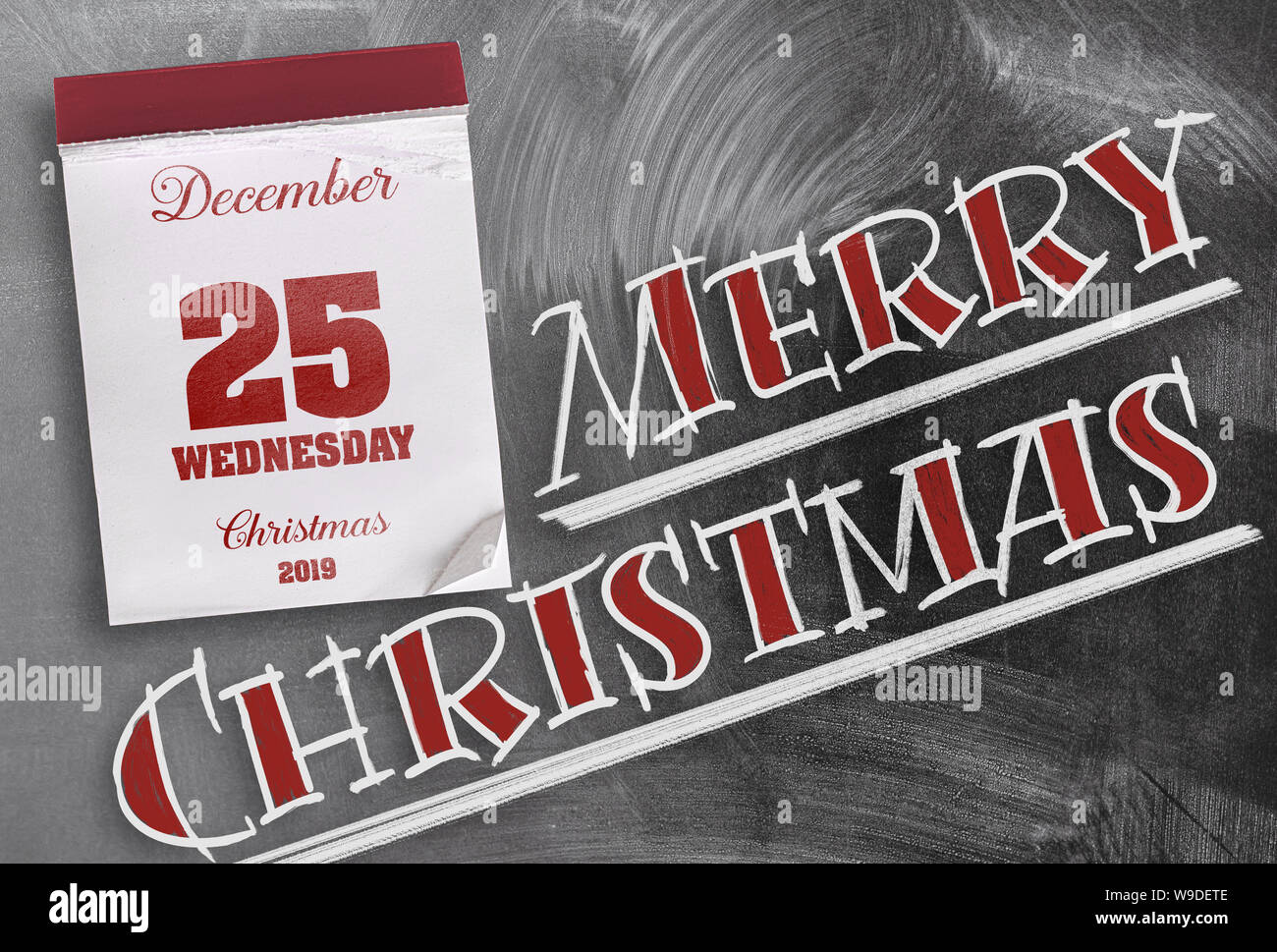 Wörter Frohe Weihnachten auf Schiefertafel mit Tear-off Kalender am 25. Dezember Stockfoto