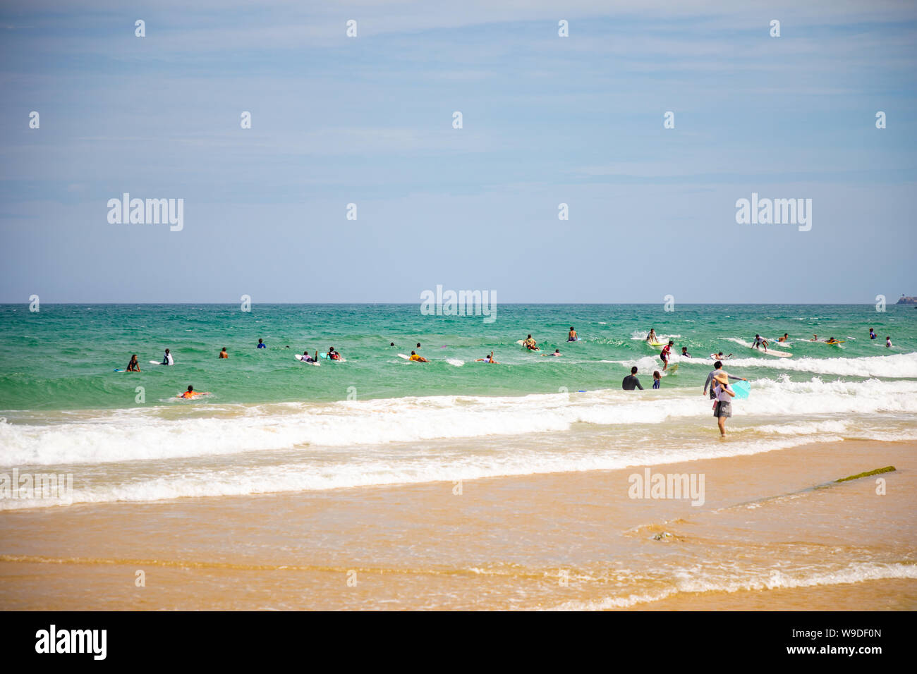 Sanya, Hainan Island, China - 22.06.2019: Leute am Strand und im Meer in Bereich für Surfen, Hainan, China Stockfoto