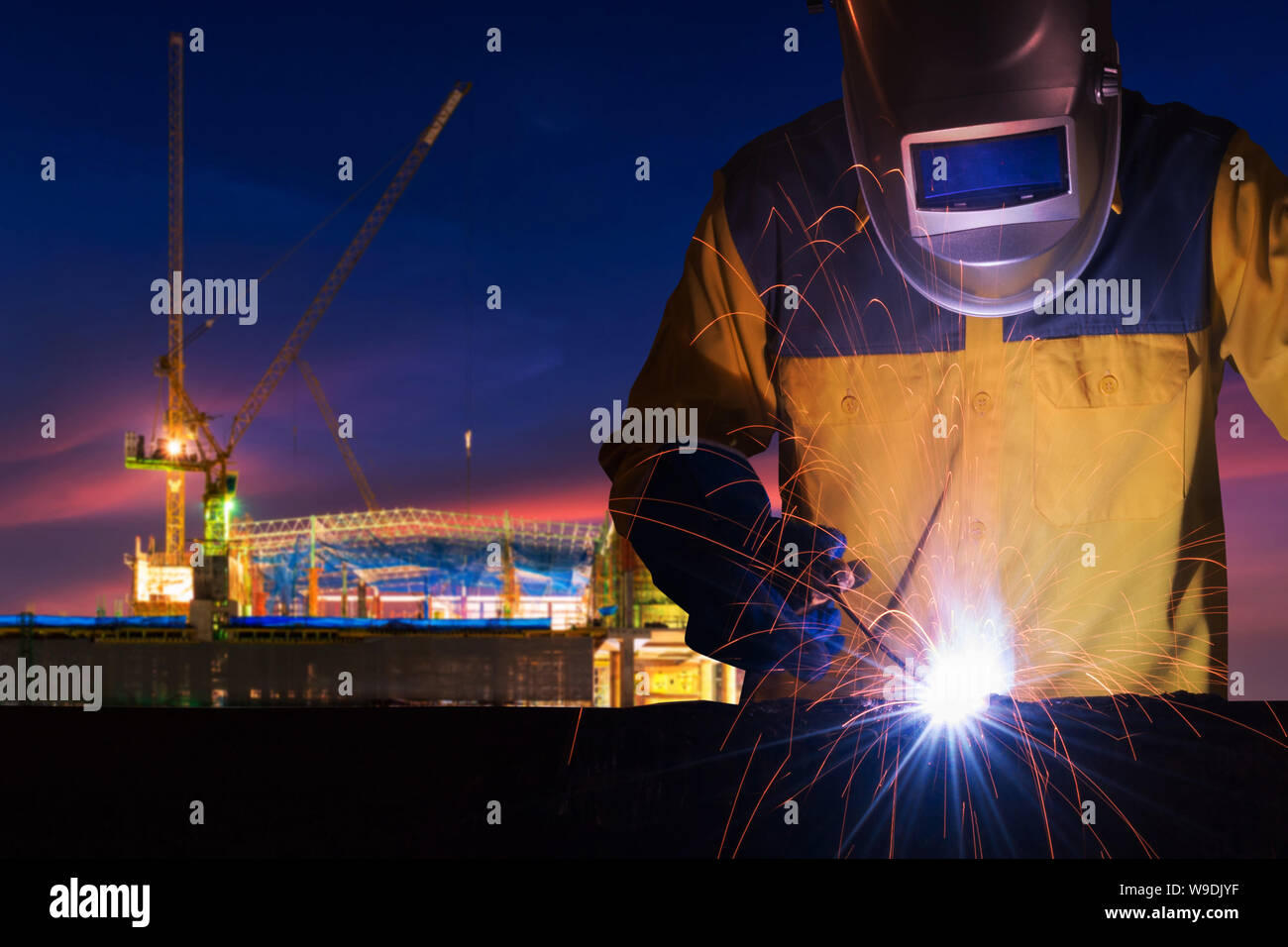 Industrielle Arbeiter schweißen Stahl Struktur für Infrastruktur Gebäude Projekt mit Baustelle im Hintergrund. Stockfoto