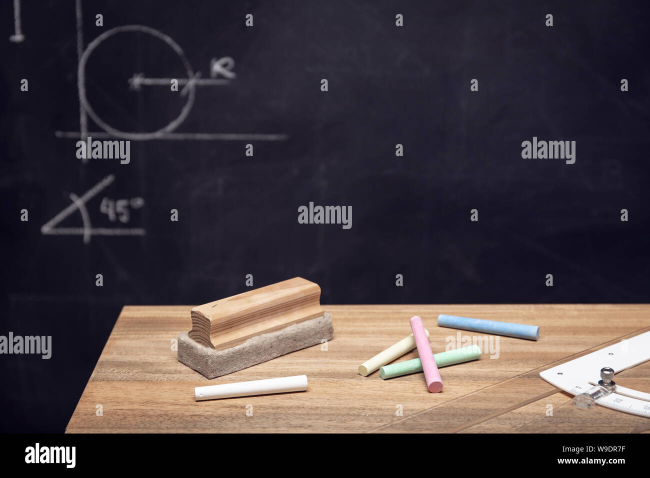 Schreibtisch mit Kreide, Radiergummi und Tafel mit Geometrie Zeichnungen. Bildung o Lernkonzept. Platz kopieren Stockfoto