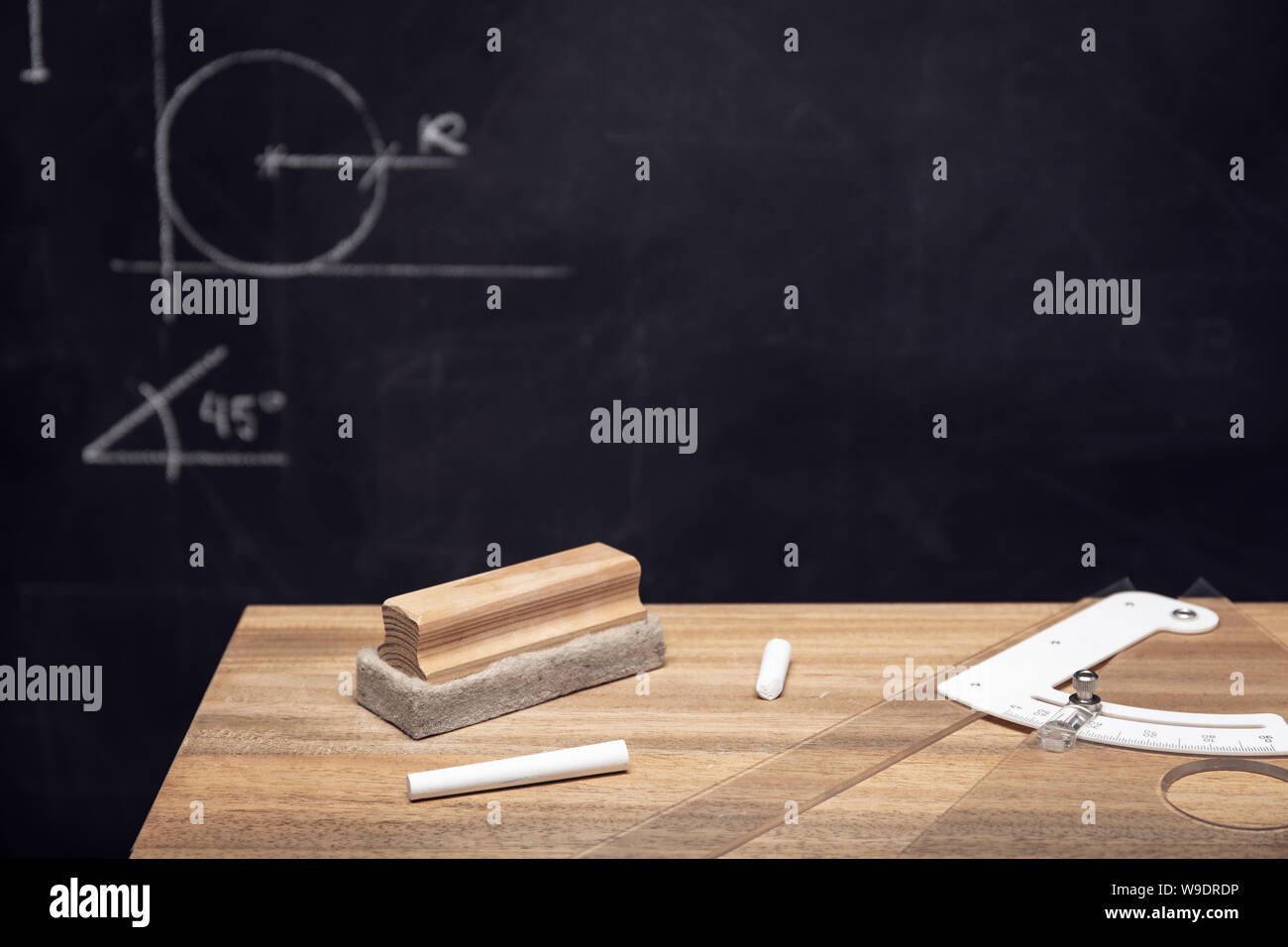 Schreibtisch mit Kreide, Radiergummi und Tafel mit Geometrie Zeichnungen. Bildung o Lernkonzept. Platz kopieren Stockfoto