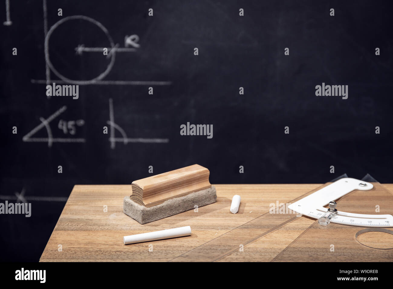 Schreibtisch mit Kreide, Radiergummi und Tafel mit Geometrie Zeichnungen. Bildung o Lernkonzept. Platz kopieren Stockfoto