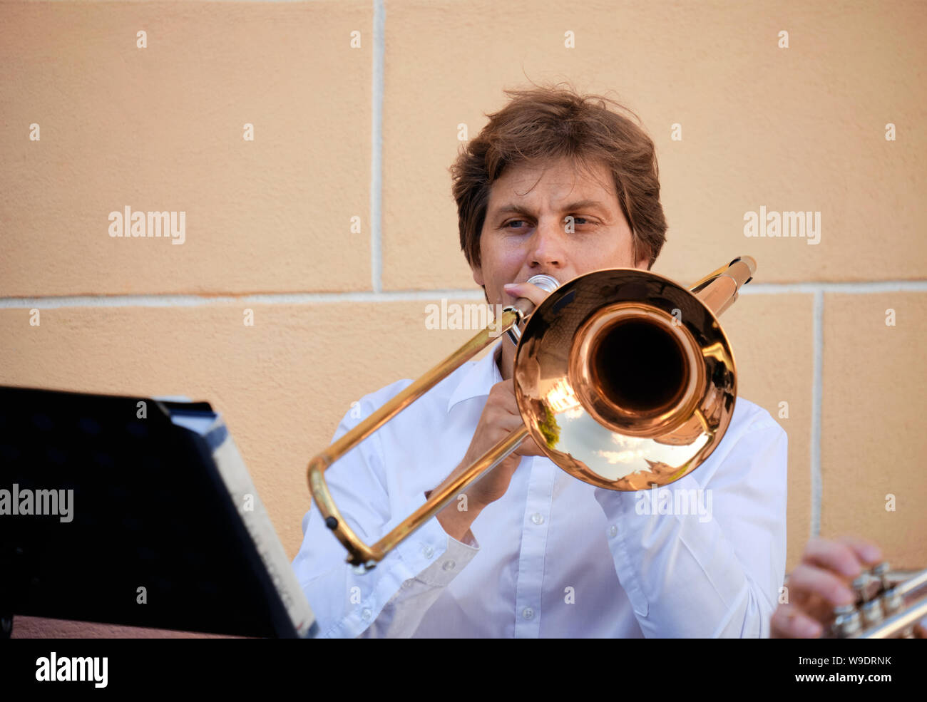 Porträt des Menschen spielen auf der Posaune bei einem Outdoor Leistung in einem Platz der Stadt. Bild von Kopf, Hände und Instrument. Sibiu, Rumänien: Juli 9, 2019 Stockfoto