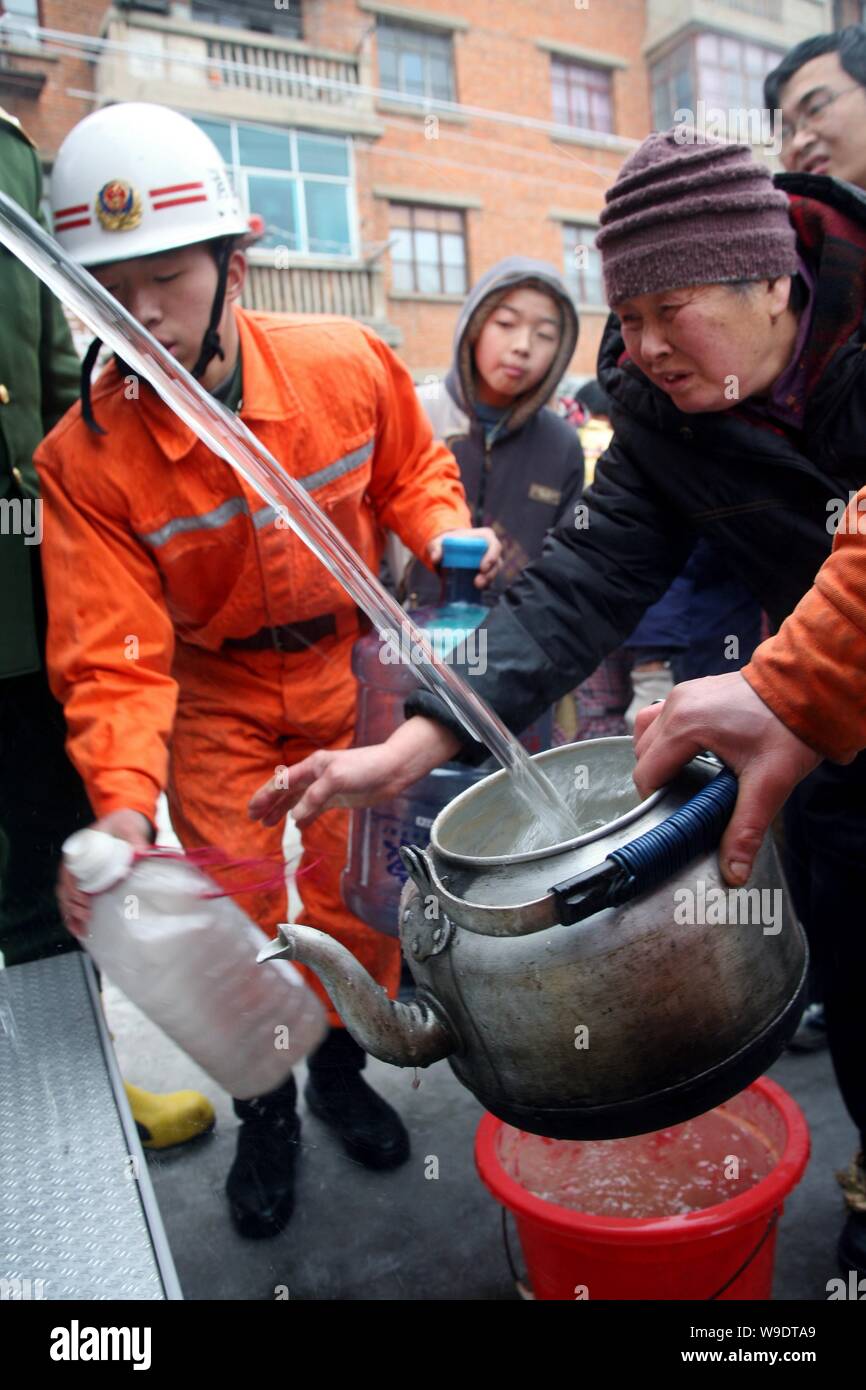 Anwohner erhalten Wasser aus einem Löschfahrzeug in Guiyang, der Hauptstadt der Provinz Guizhou im Südwesten Chinas, 3. Februar 2008. Verkehrsmittel sind startin Stockfoto