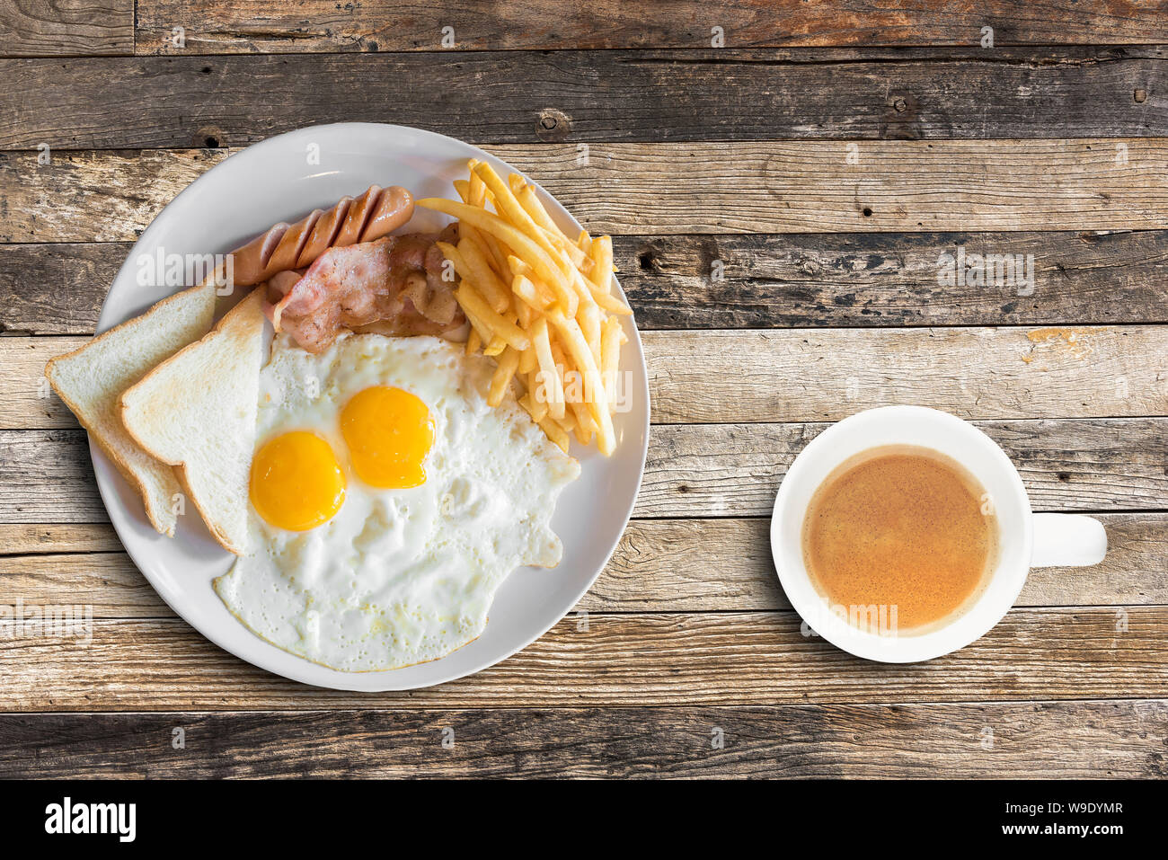 Blick von oben auf ein amerikanisches Frühstück mit Rührei und Kaffee Tasse auf hölzernen Tisch Hintergrund. Stockfoto