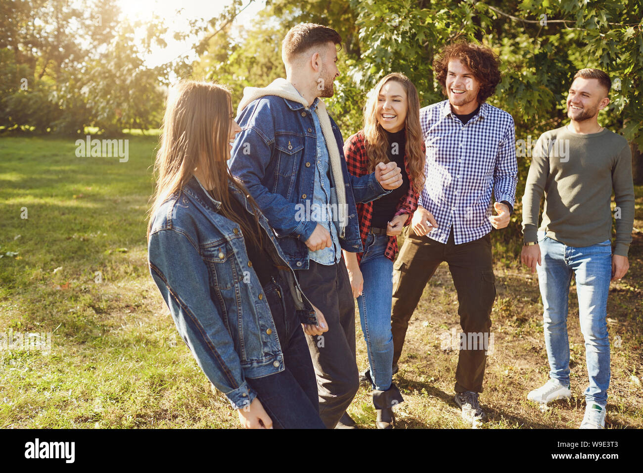 Junge Leute zum Lachen beim Stehen in einem Park im Frühling. Stockfoto