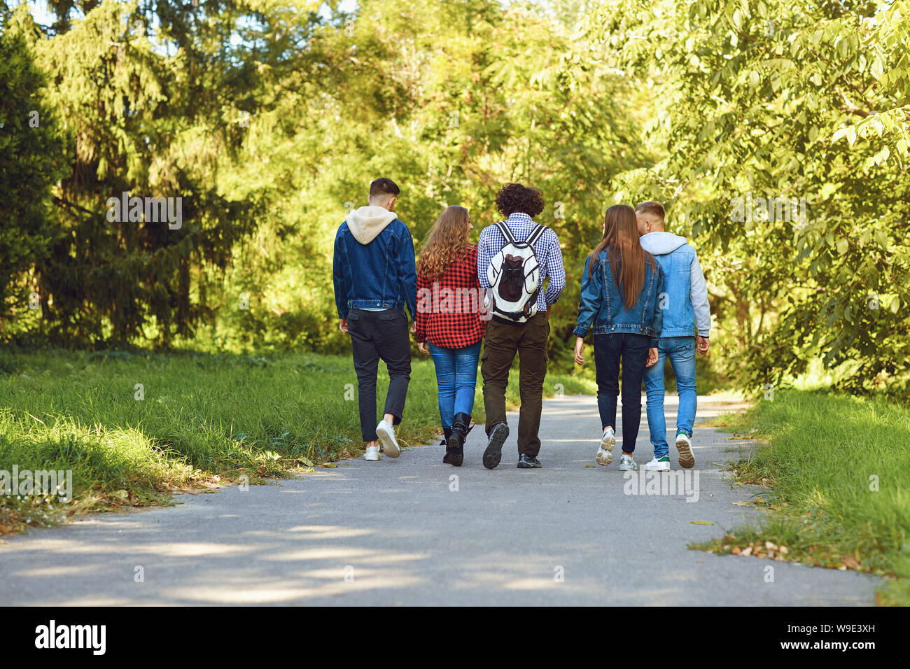 Gruppe der modernen Menschen im Park spazieren Stockfoto
