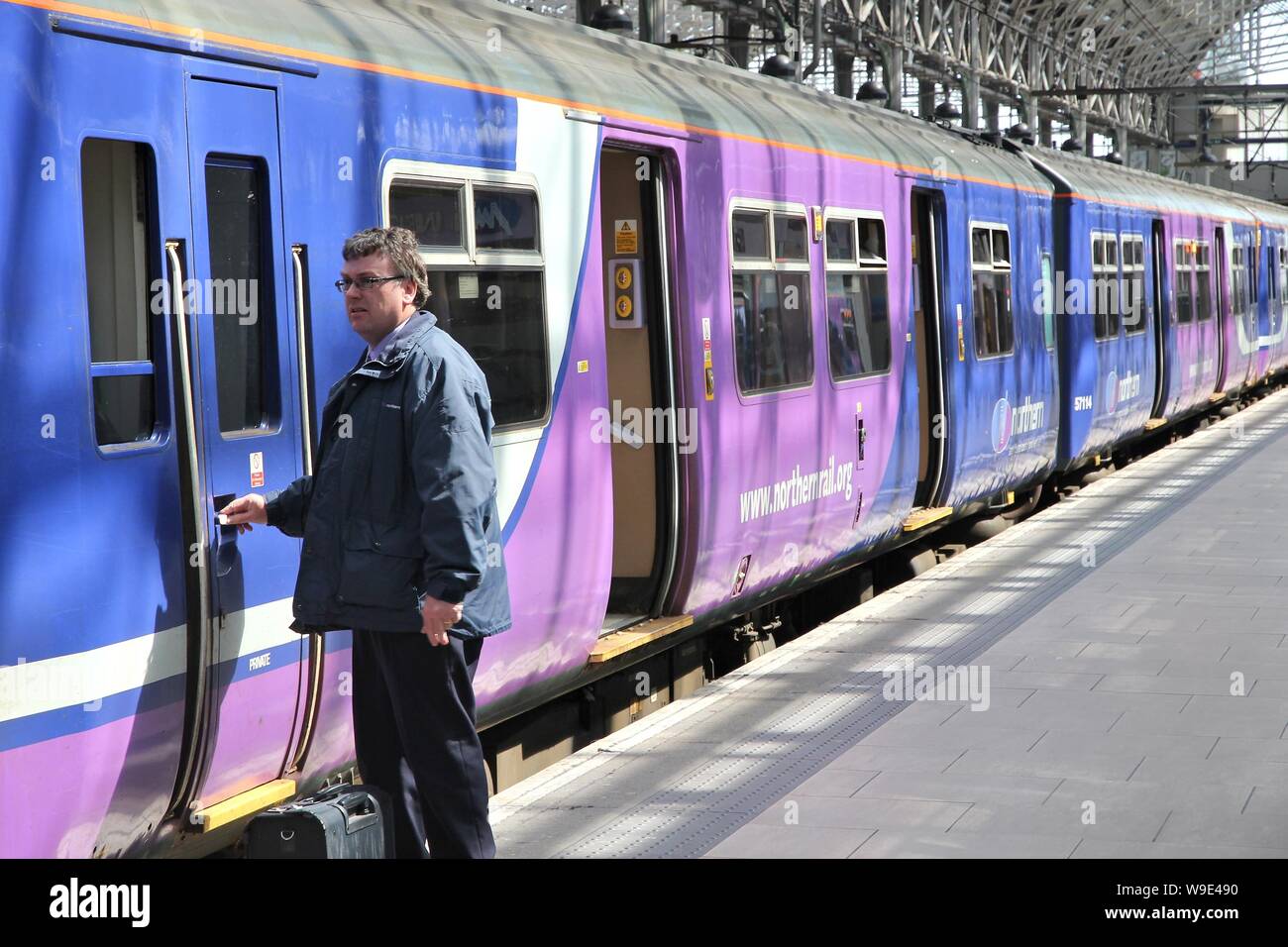 MANCHESTER, Großbritannien - 23 April, 2013: Arbeiter boards Northern Rail Zug in Manchester, UK. NR ist Teil der Serco-Abellio Joint Venture. NR hat Flotte von 313 t Stockfoto