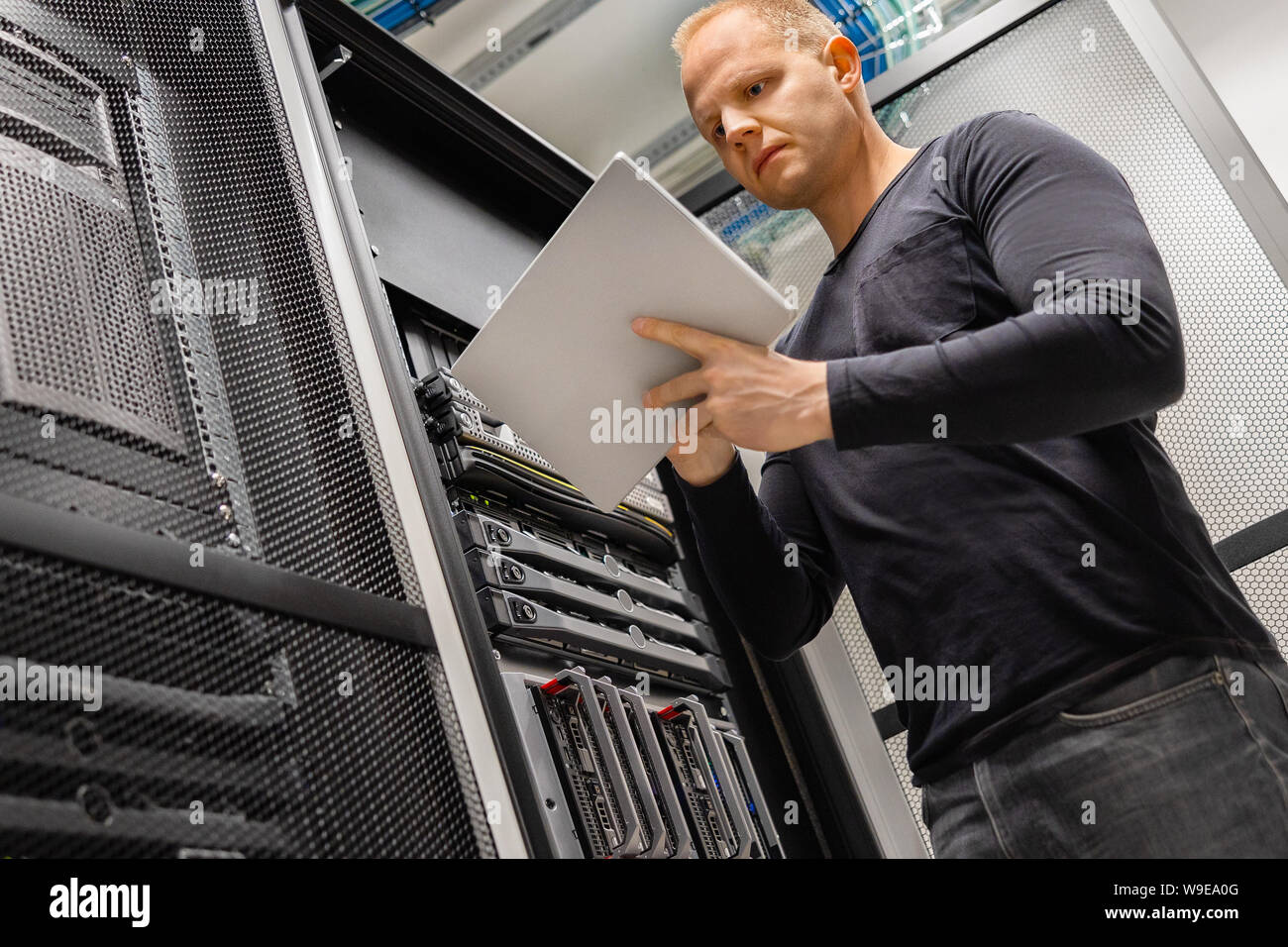 Männliche IT-Techniker mit Tablette im Rechenzentrum zur Überwachung von Netzwerk und Servern Stockfoto