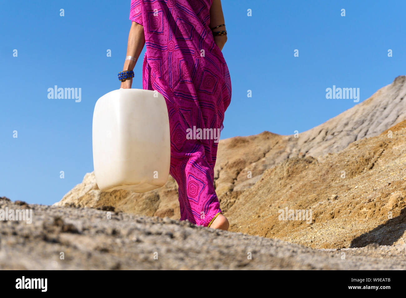 Ein Mädchen in ethnische Kleidung geht für Wasser mit einem Kunststoff Kanister Stockfoto