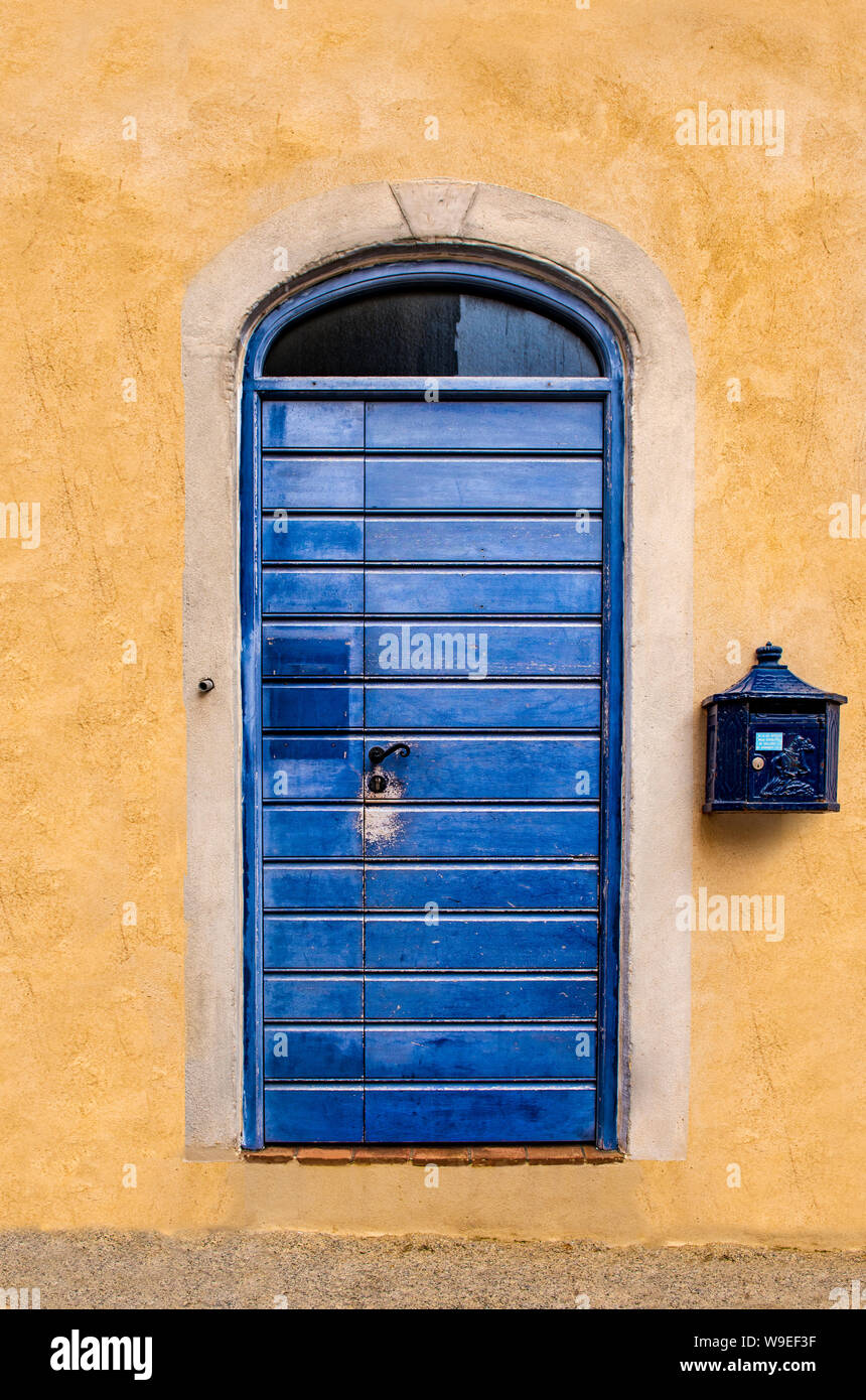 Blaue Tür mit ockerfarbenen Wände Stockfoto