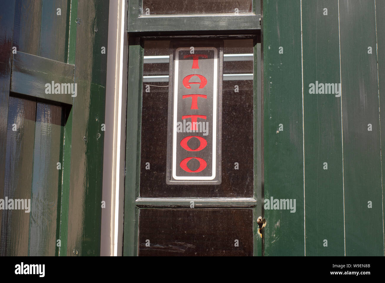 Tattoo Zeichen auf die Grüne Wand von einem Tattoo Shop Stockfoto