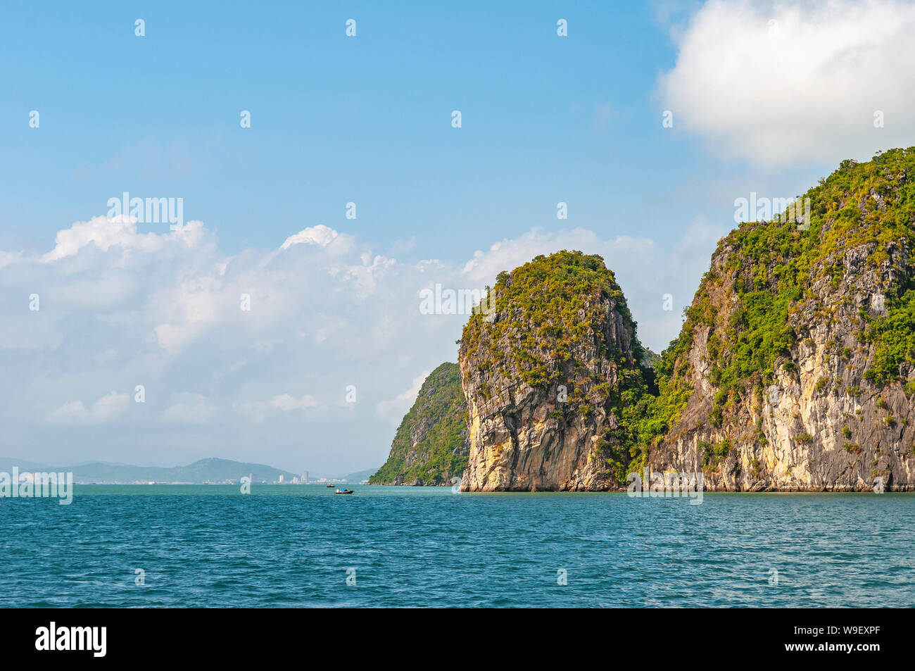 Die Geologische karst Felsformationen der Halong Bucht im Südchinesischen Meer mit Blick auf die Skyline von Haiphong Stadt im Hintergrund, North Vietnam. Stockfoto