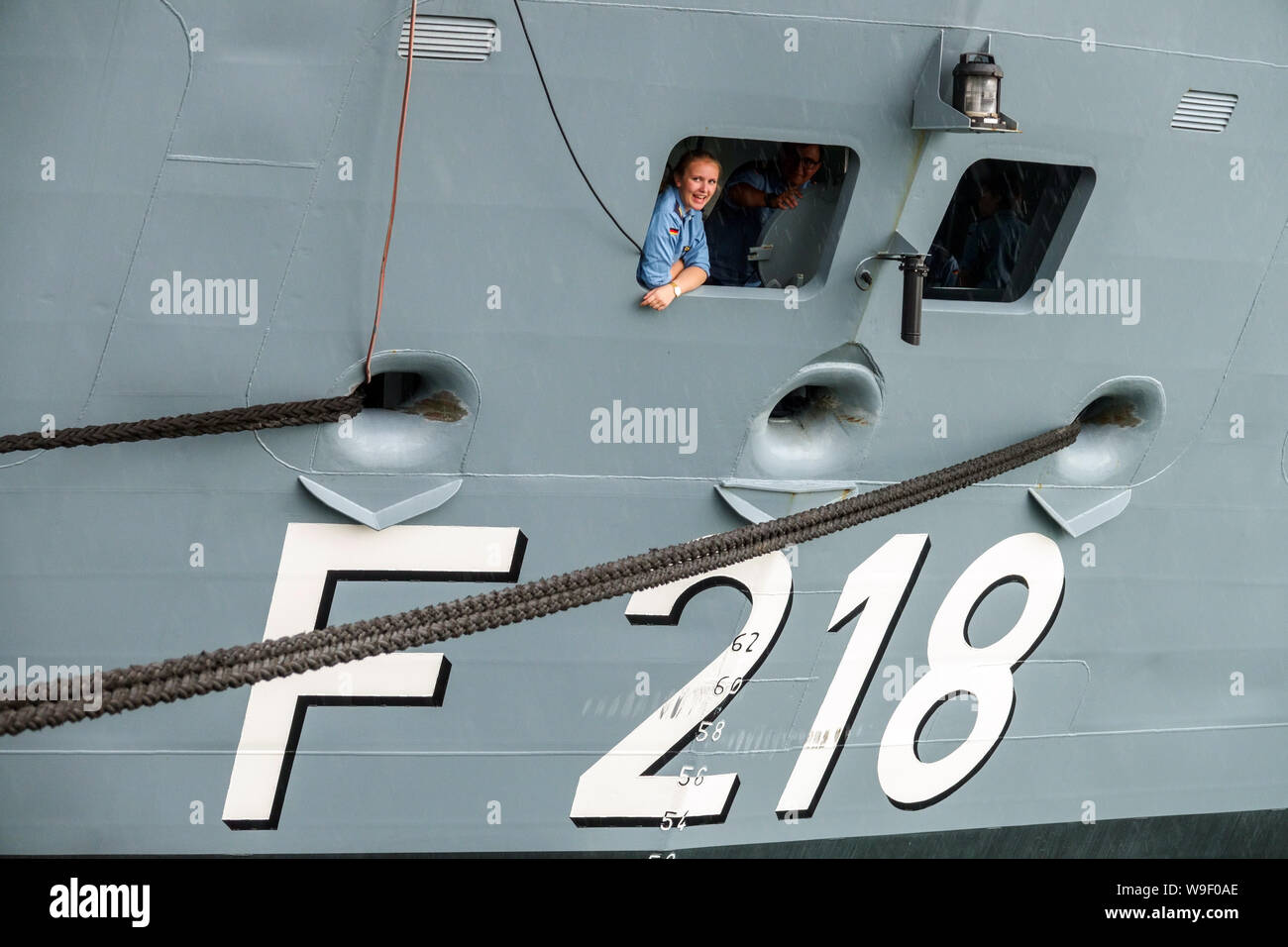 Ein Besatzungsmitglied Frau in einem Fenster am Heck eines Schiffes, deutsche Armeefrauen deutsche Fregatte Mecklenburg-Vorpommern in Rostock Deutschland marine Stockfoto