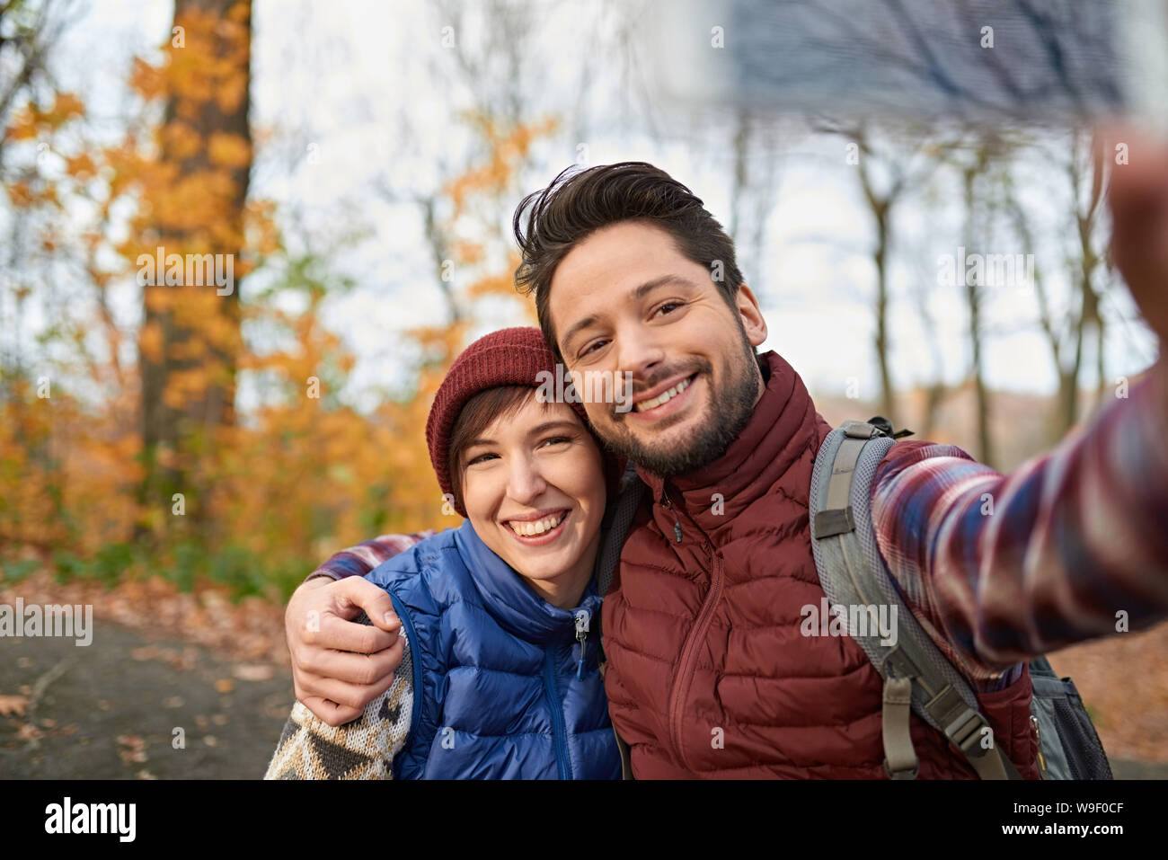Paar der kanadischen Millennials selfies nehmen mit einem Smartphone in einem Fall Forrest Stockfoto