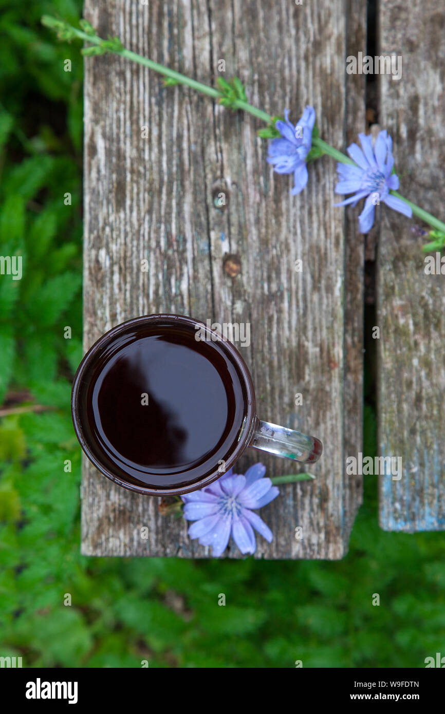 Cup der Zichorie Drink auf am Rande der alten Hintergrund Holz im Garten. Rustikale Ansicht von oben. Stockfoto
