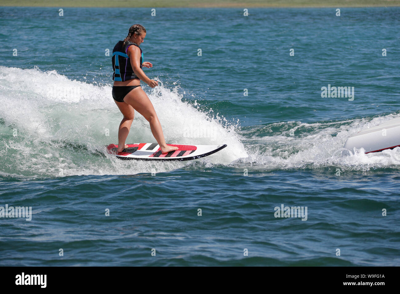 Eine Frau, die beim Surfen auf einem Boot. Stockfoto