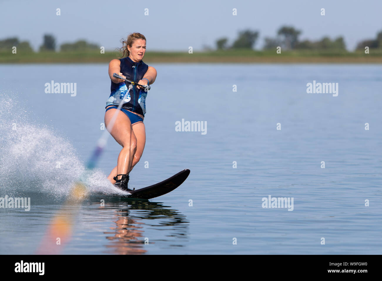 Eine Frau Wasserski auf einem ruhigen See. Stockfoto