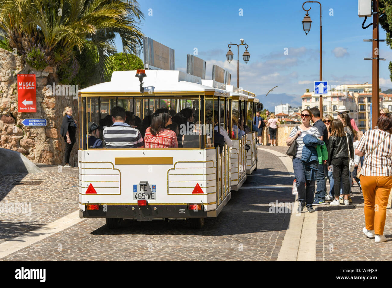 CANNES, Frankreich - April 2019: Menschen reiten auf einem touristischen Straße Bahn, die Besucher von Cannes den Hügel hinauf zur Kirche Unserer Lieben Frau von Esperance Stockfoto