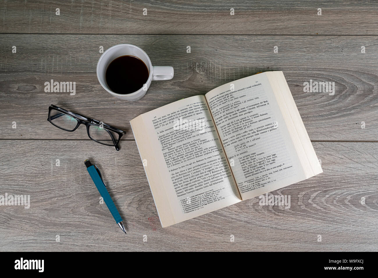 Ein Buch auf einem Tisch mit einer Tasse Kaffee Stockfoto