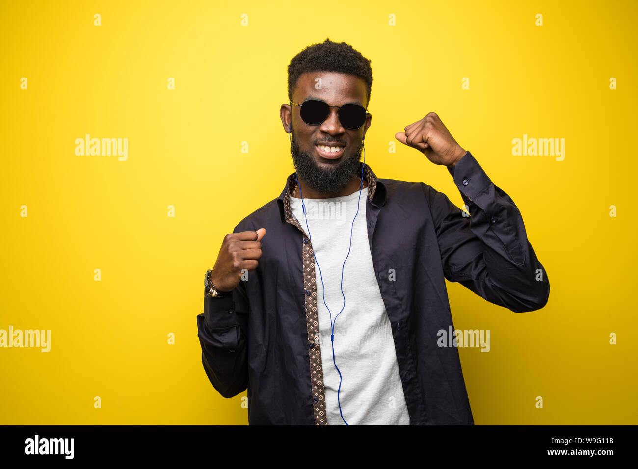 Junge afrikanische amerikanische Mann auf lebendige gelb Hintergrund feiert einen Sieg Stockfoto