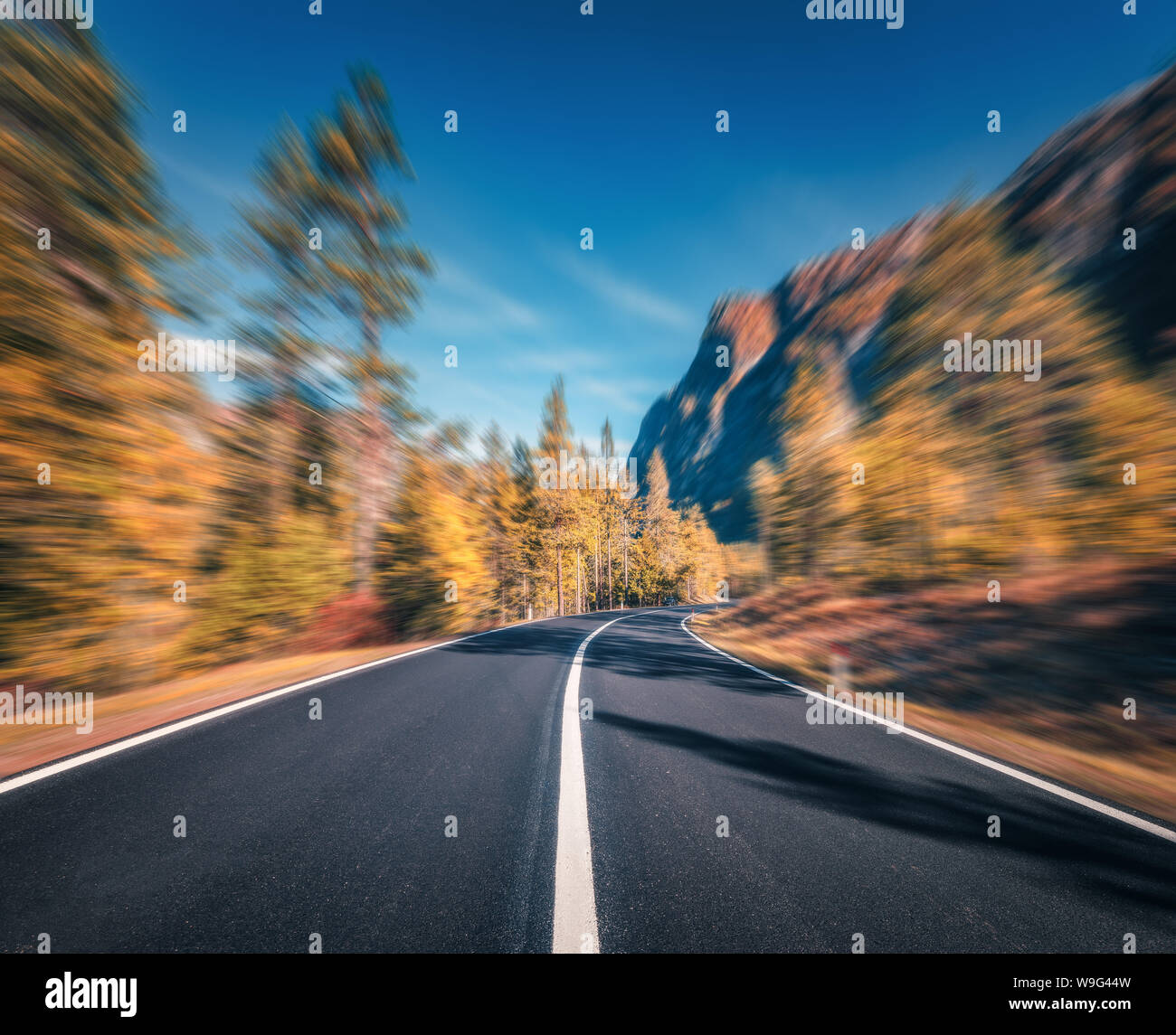 Mountain Road im Herbst Wald bei Sonnenuntergang mit Motion blur Effekt Stockfoto