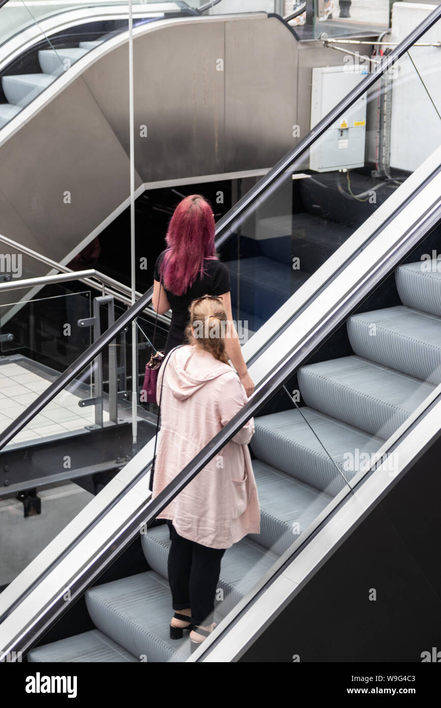 Zwei Frauen, eine Fahrtreppe in einem Einkaufszentrum oder das Einkaufszentrum Stockfoto