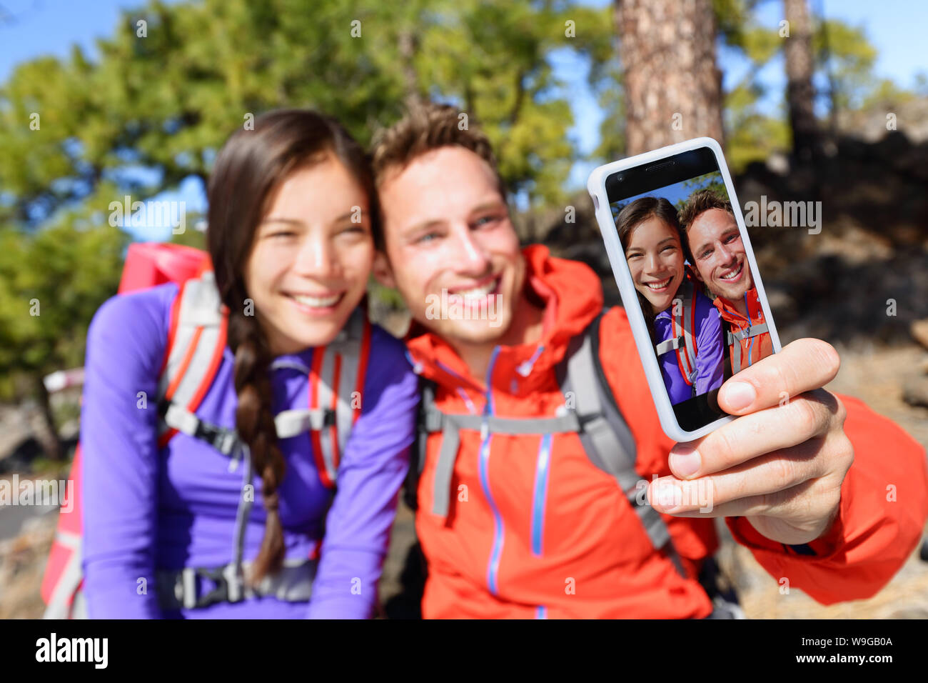 Selfie Paar mittels smart phone Kamera, Foto, Wandern in der Natur mit Smartphone. Glückliches Paar, Selbstbildnis Bild mit App. Mann und Frau gemeinsam Spaß zu haben. Fokus auf dem Bildschirm. Stockfoto
