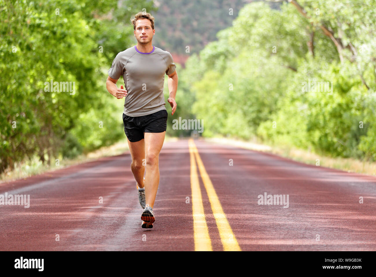 Sport und Fitness runner Mann laufen auf der Straße Training für Marathon laufen, high intensity intervall training Sprint Training im Freien im Sommer. Männliche Athlet Sport Modell fit und gesund Bestrebungen. Stockfoto