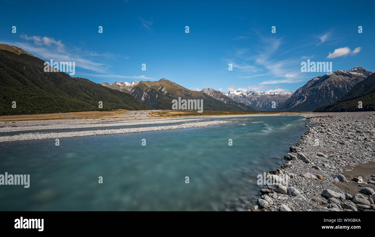 Blaue Gletscherwässer des Waimakariri-Flusses fließen durch ein Tal, das von den Bergen des Arthur's Pass, Neuseeland, umgeben ist Stockfoto