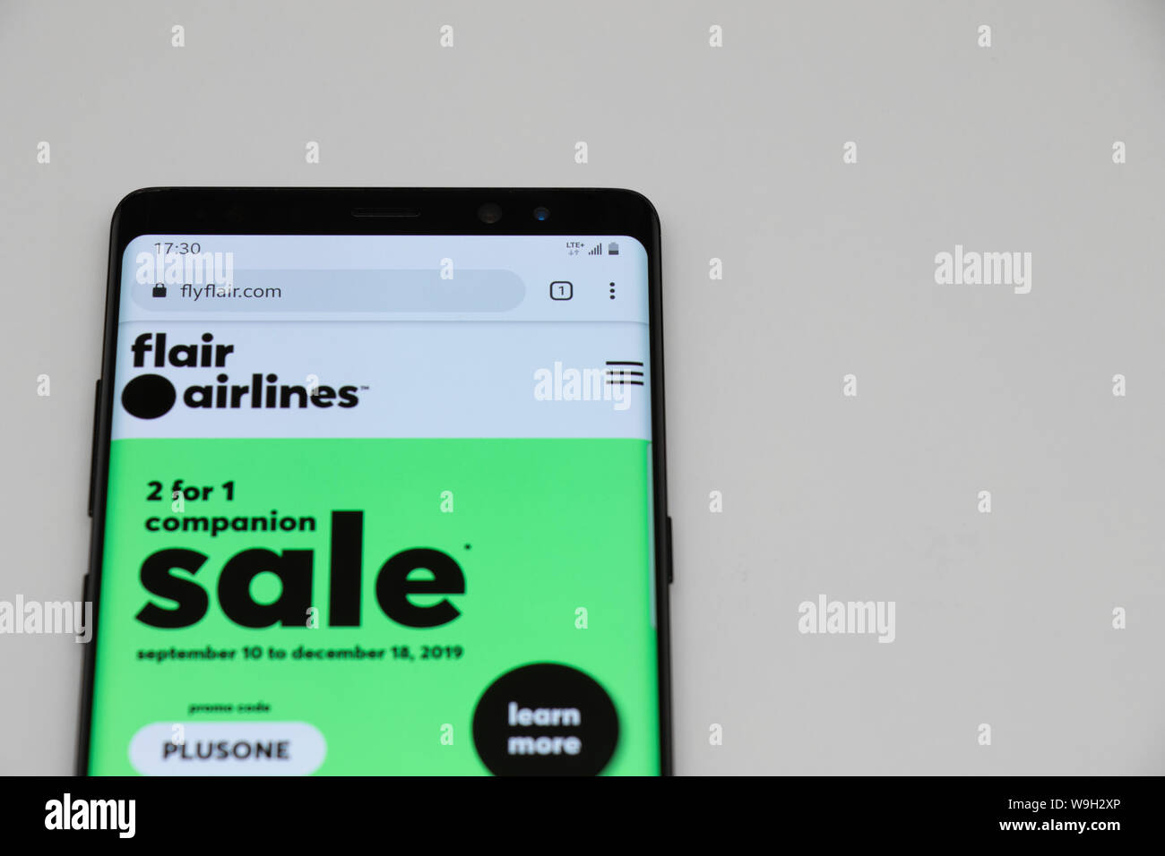 Flair Airlines Website auf einem Android Handy auf einem weißen Tisch gelegt. Stockfoto