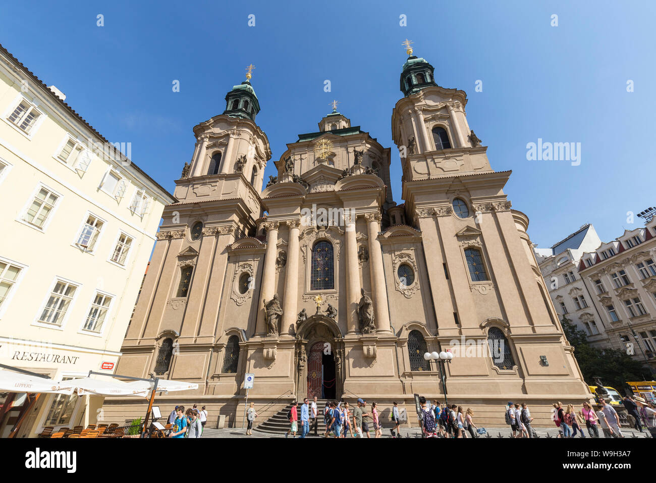Touristen vor der Kirche von St. Nikolaus in der Altstadt (Stare Mesto), Prag in der Tschechischen Republik, an einem sonnigen Tag. Stockfoto