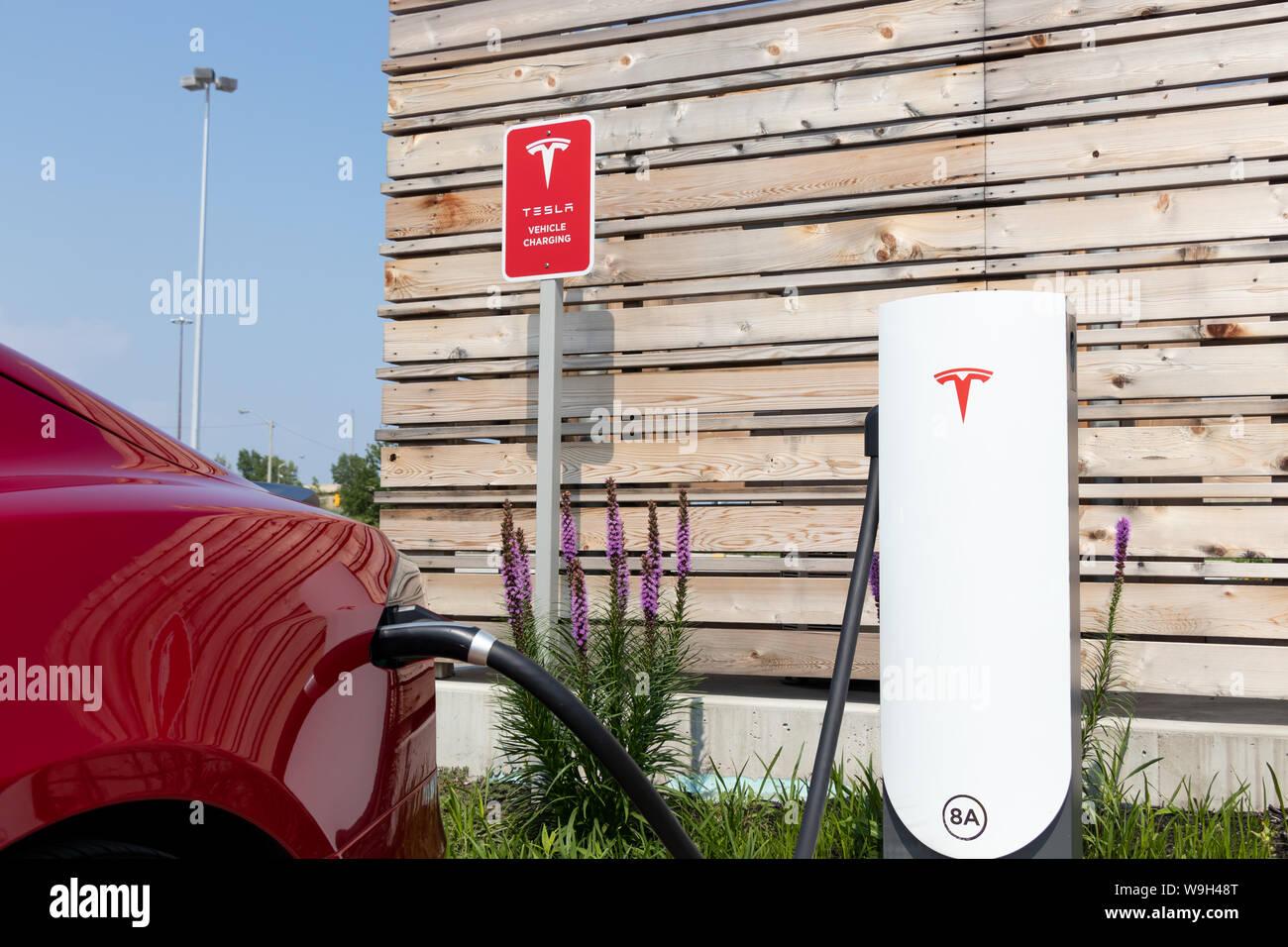 Red Tesla Model S Plug-in, das Aufladen bei Tesla Urban Kompressor. Stockfoto