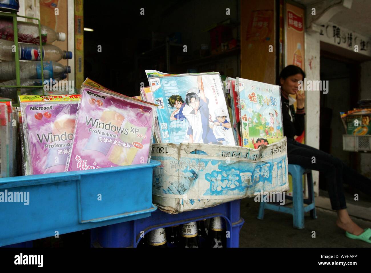 Ein chinesischer Anbieter verkauft Raubkopien von Microsoft Windows XP-Software und Raubkopien von Cartoon-Film-DVDs in der Straße von Shanghai 18 Mai 2007. Stockfoto