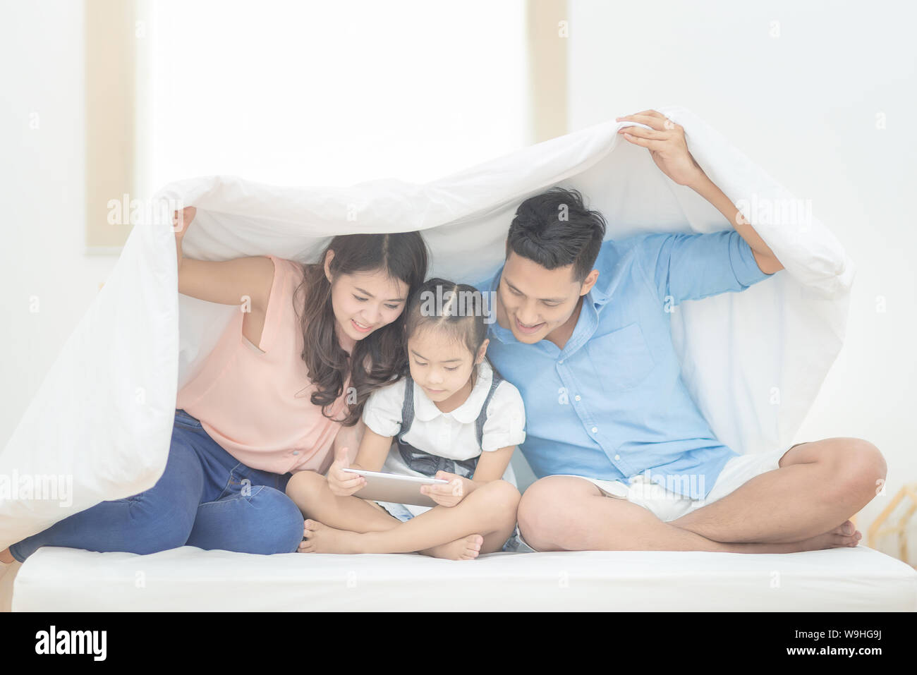 Happy Family im Schlafzimmer, asiatische Vater und Mutter ihre Tochter Kind zu Hause zu studieren. Stockfoto