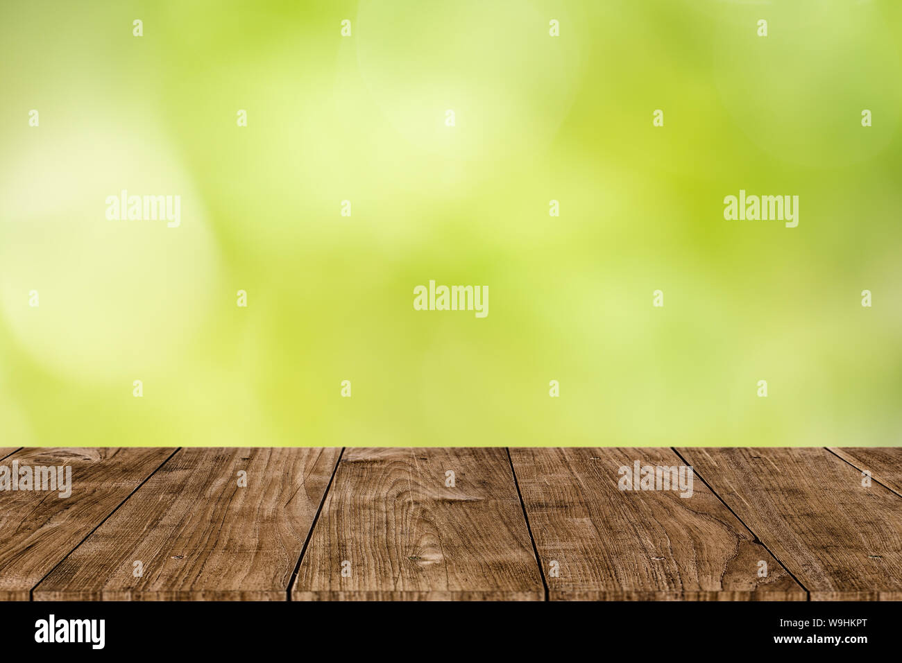 Blur grüner Hintergrund mit hölzernen Tischplatte Vordergrund für Produkt Display montage Werbefläche Stockfoto