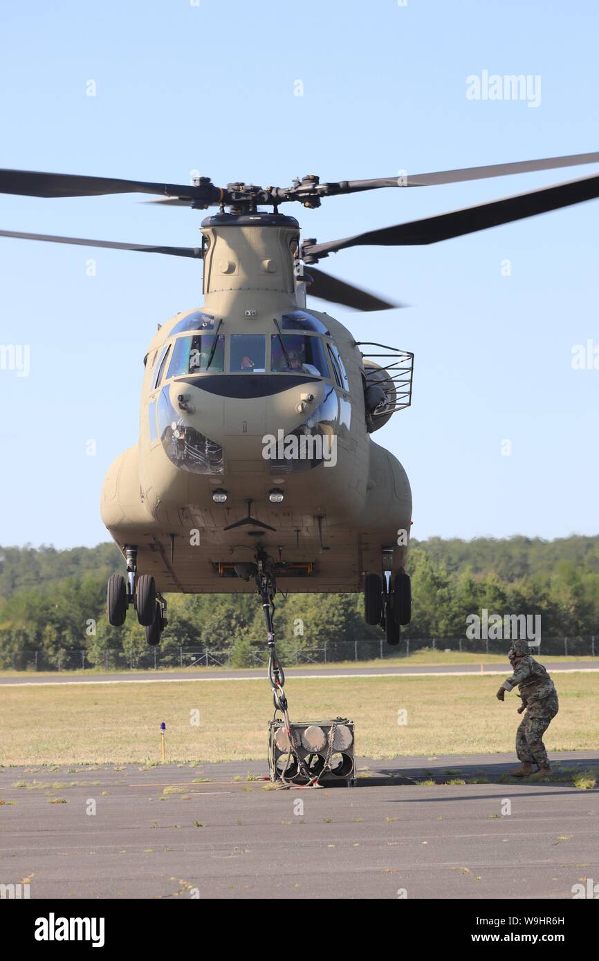 Schüler der 89 B Munition liefern Kurs verbinden ein mock Munition Palette zu einem CH-47 Chinook Hubschrauber Aug 1, 2019, als Teil der Schlinge - last Ausbildung bei Sparta-Fort McCoy Flughafen am Fort McCoy, Wis die Chinook und die Crew sind ab dem 7. Bataillon, 158 Aviation Regiment des neuen Jahrhunderts, Kansas. Die Munition liefern, von der 13 Bataillon gelehrt, 100 Regiment am Fort McCoy, ist einen 4-wöchigen Kurs, der eine Schulung für die Soldaten, die Umgliederung der 89 B militärische berufliche Spezialität sind. Die Schlinge - last Training ist einer der letzten großen Ausbildung Veranstaltungen während des Kurses. Ein s Stockfoto