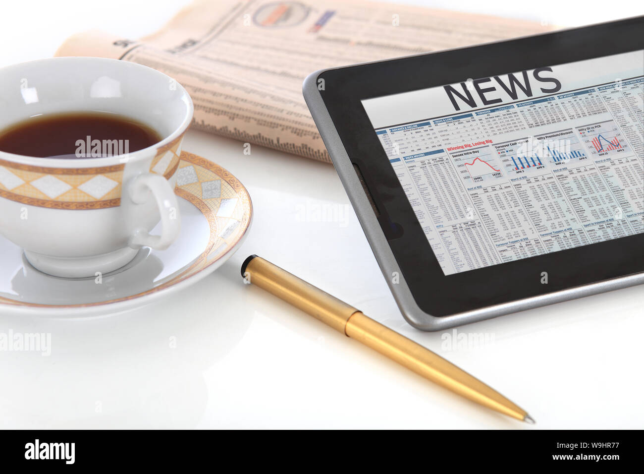 Nahaufnahme eines digitalen Tablets mit Finanzzeitung und Stift Stockfoto